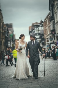 Bride and groom walk on cobbled street