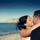 Bride kisses groom on the beach