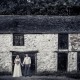 Bride and groom in front of cottage