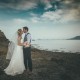 Bride and groom kiss by the water